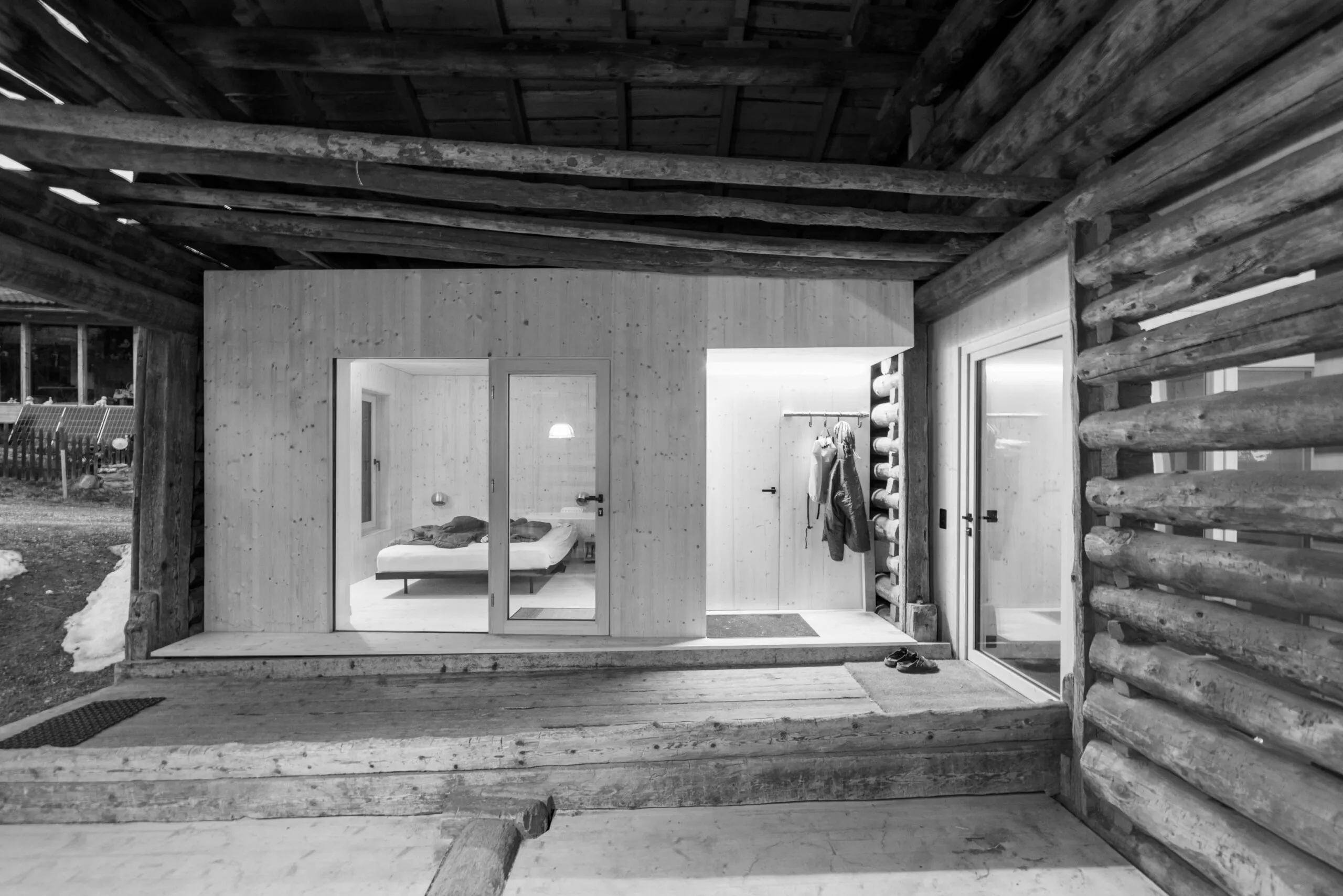 Stallumbau: Raumkörper aus hellem Holz mit Schlafzimmer und Garderobe zwischen den Rundholzwänden